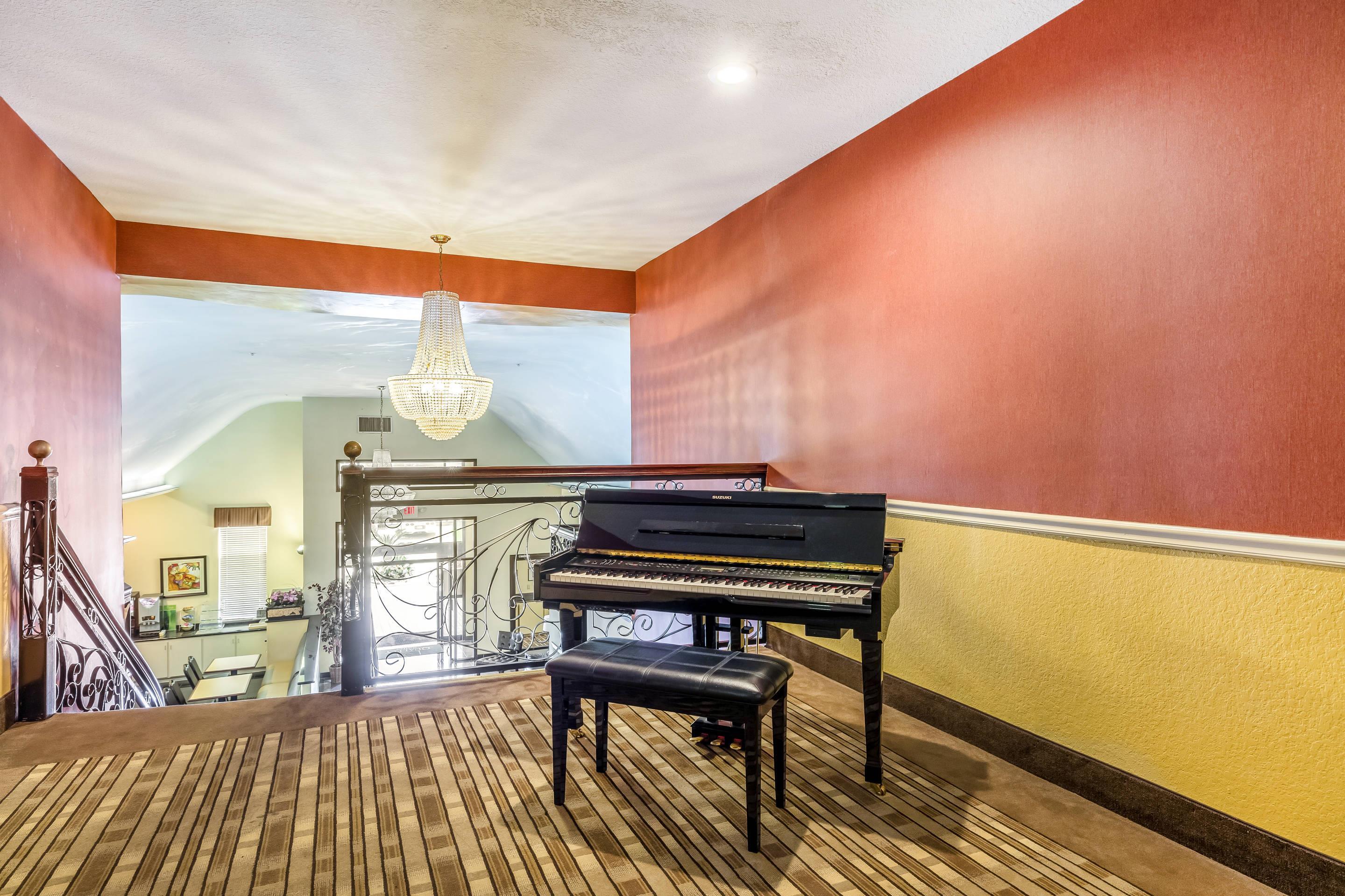Sitting area and piano on second floor | Quality Suites North