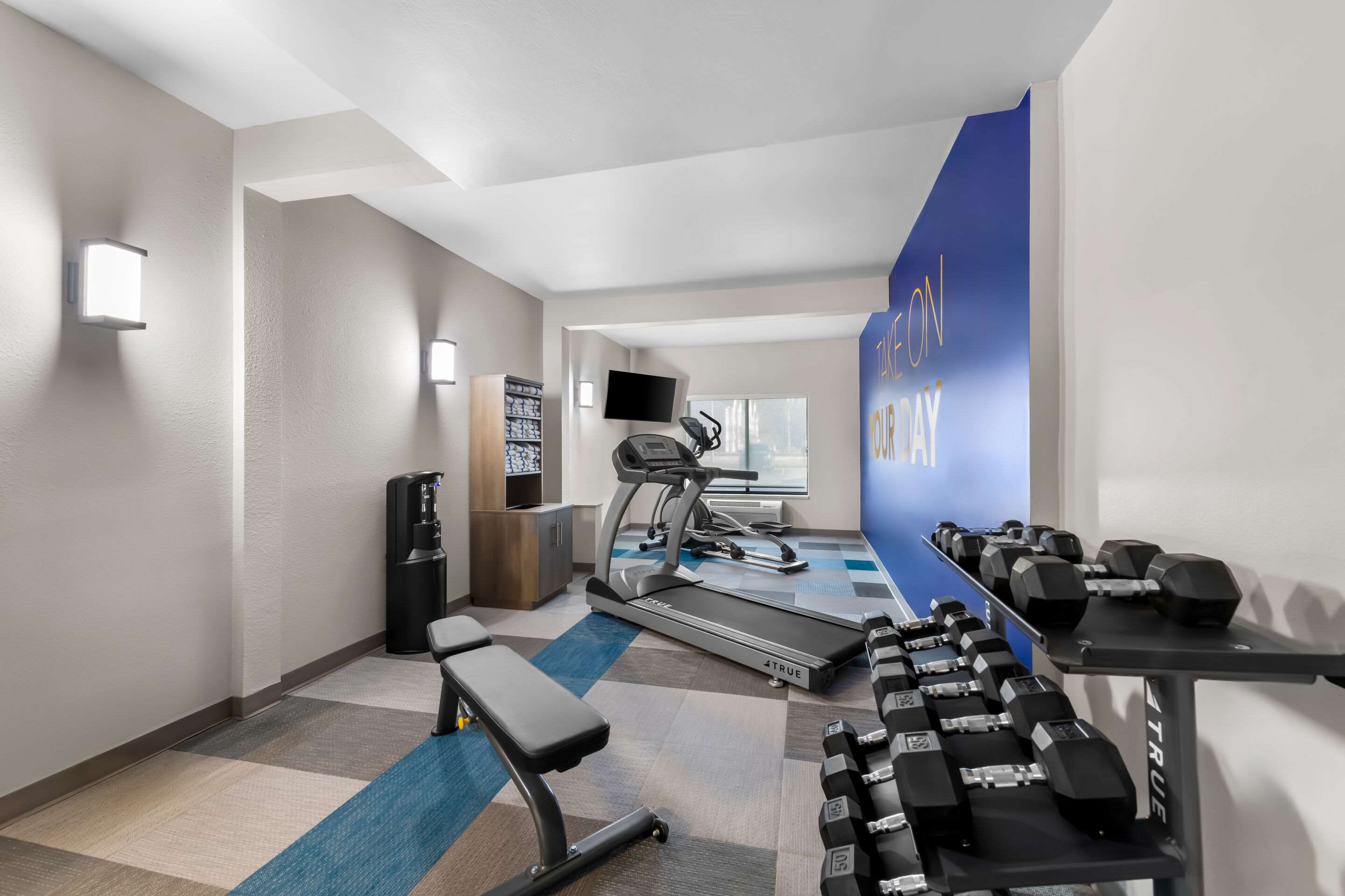 Exercise room with cardio equipment and weights | Comfort Suites
