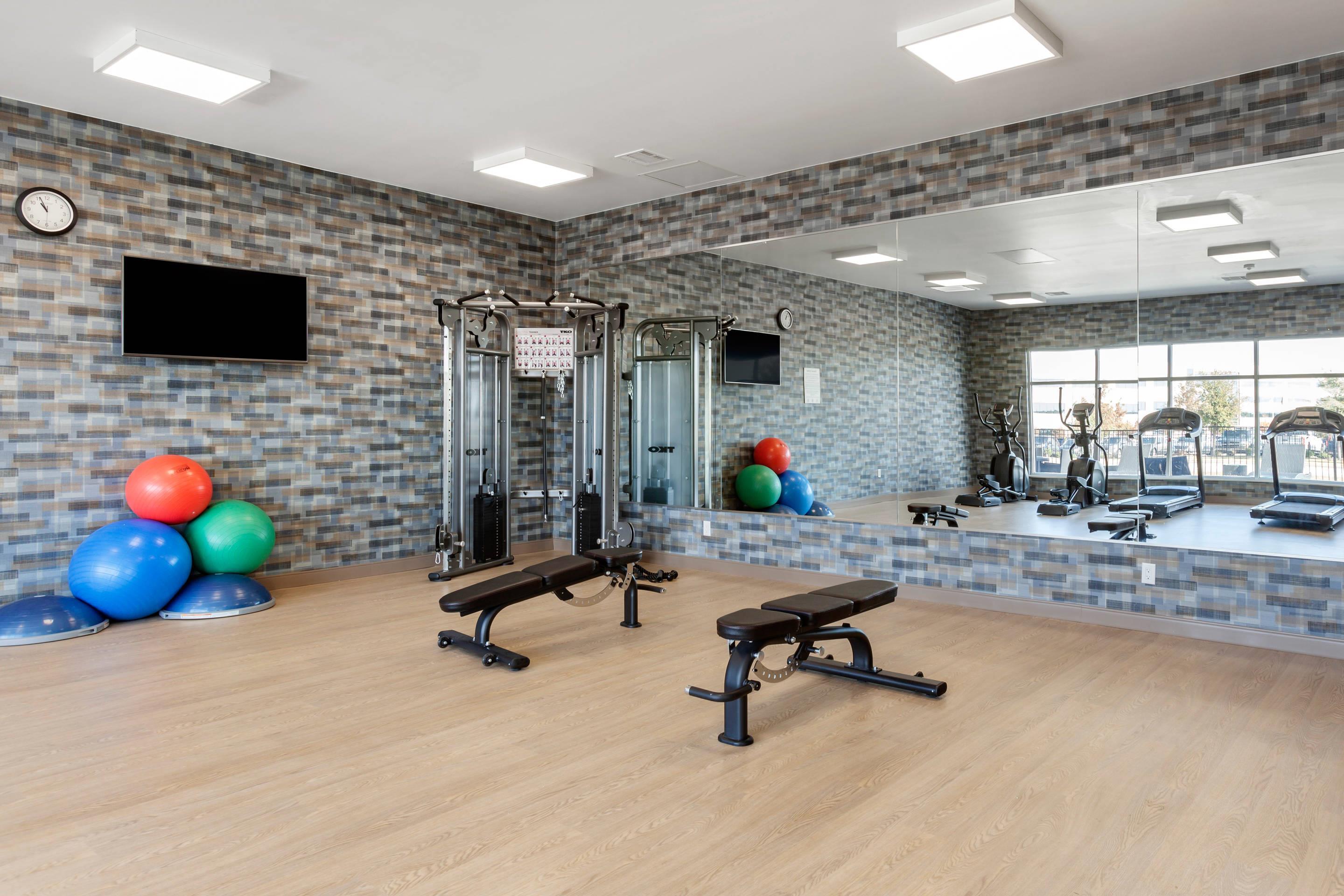 Exercise room with cardio equipment and weights | Cambria Hotel Richardson - Dallas