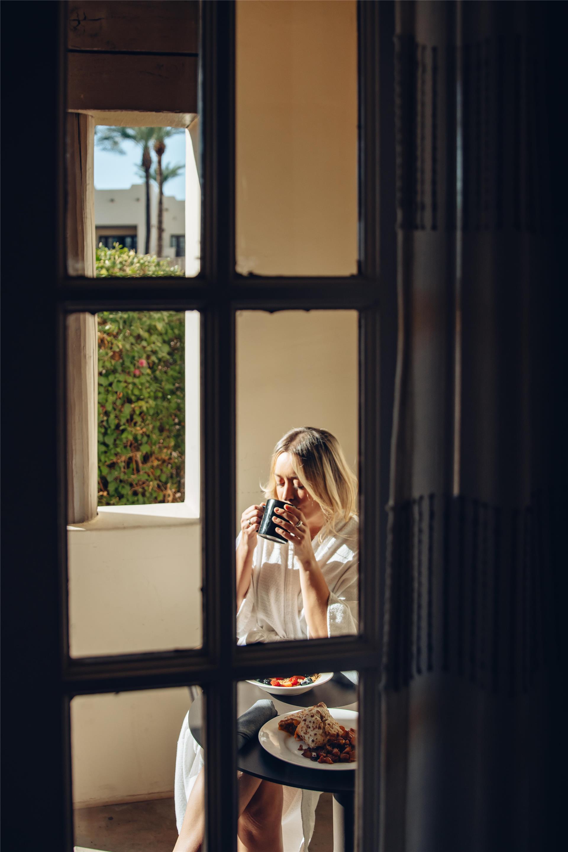 Woman enjoying breakfast on room balcony | The Wigwam