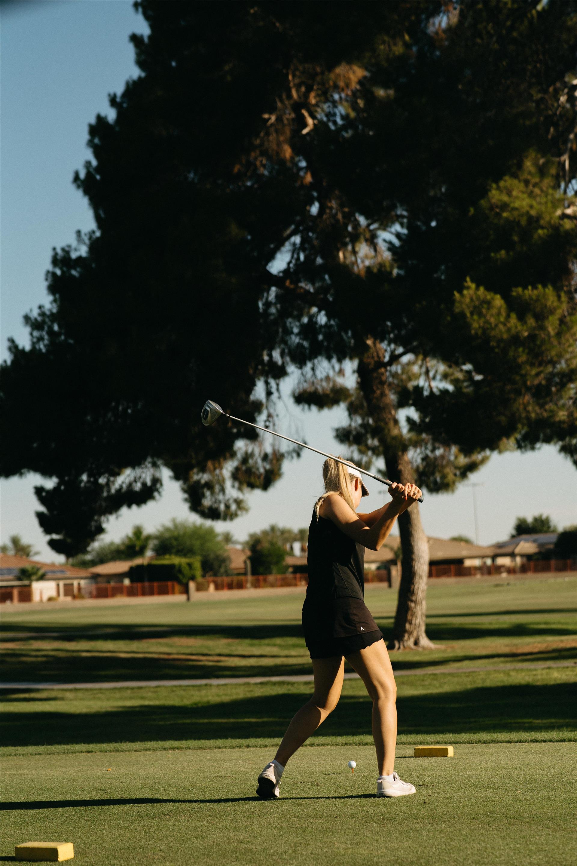 Woman teeing off on golf course | The Wigwam
