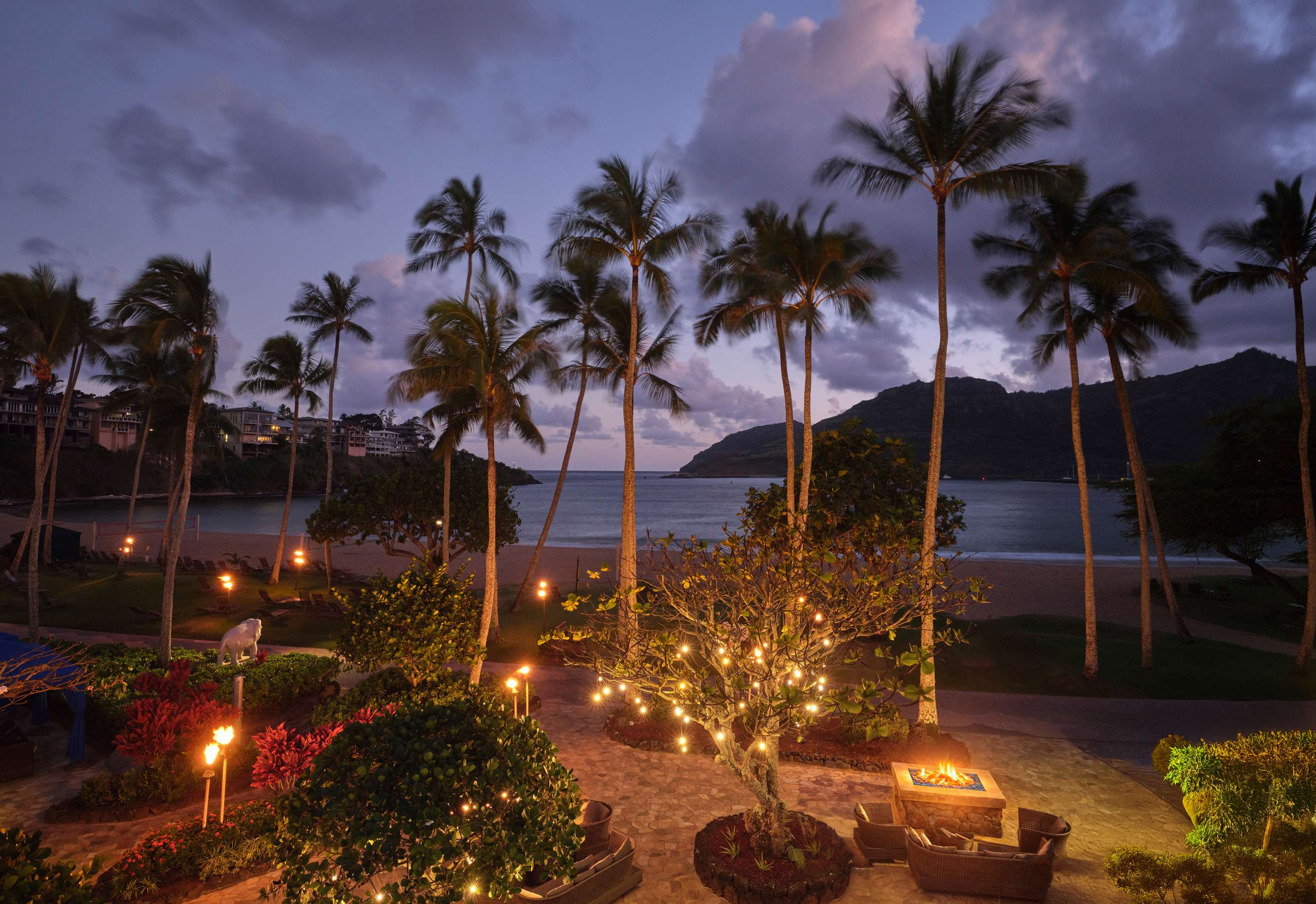 TRS Kauai Exterior Evening View of Kalapaki Beach and Fire Pits