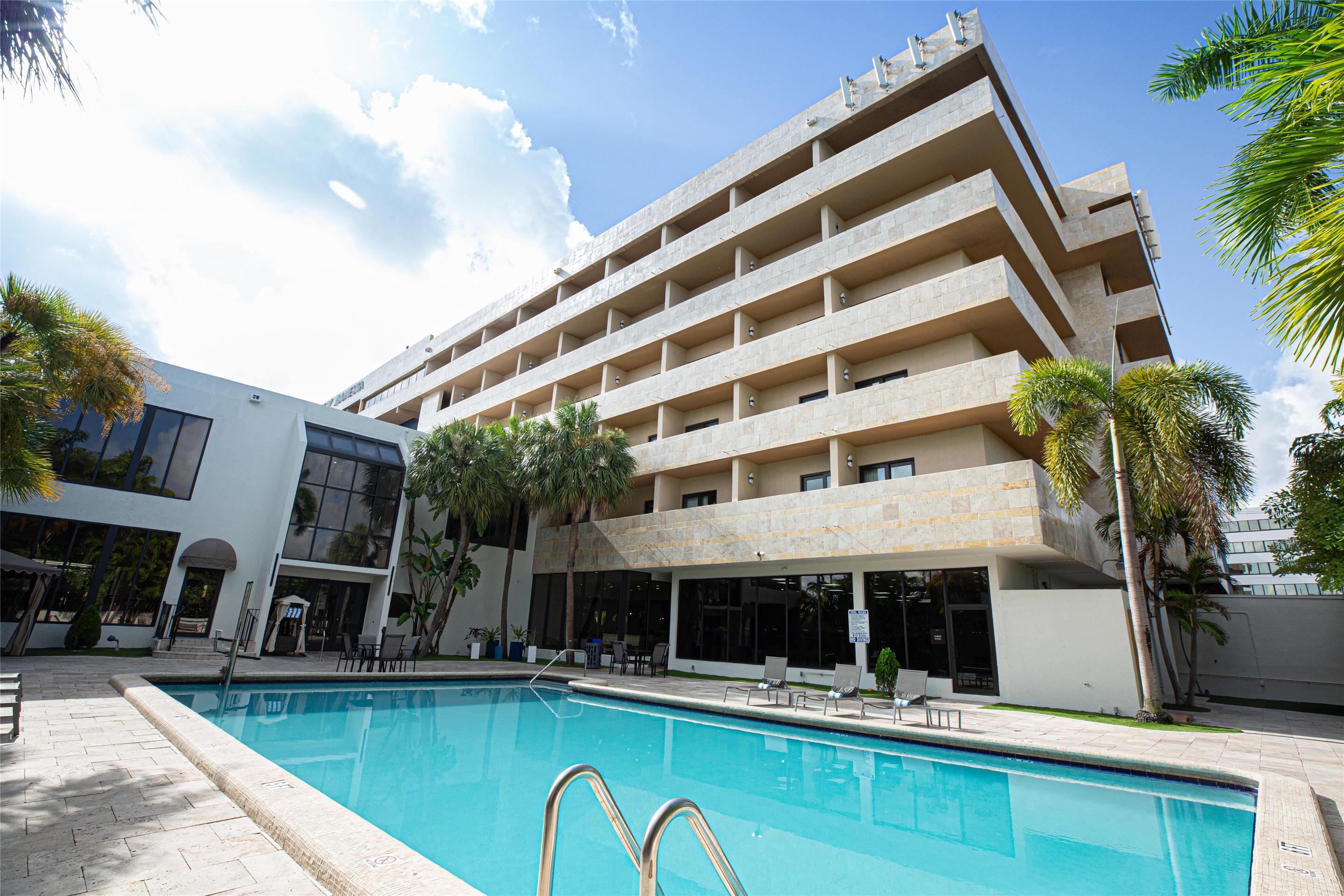 Outdoor Pool and Lounge Chairs | Regency Miami Airport by Sonesta