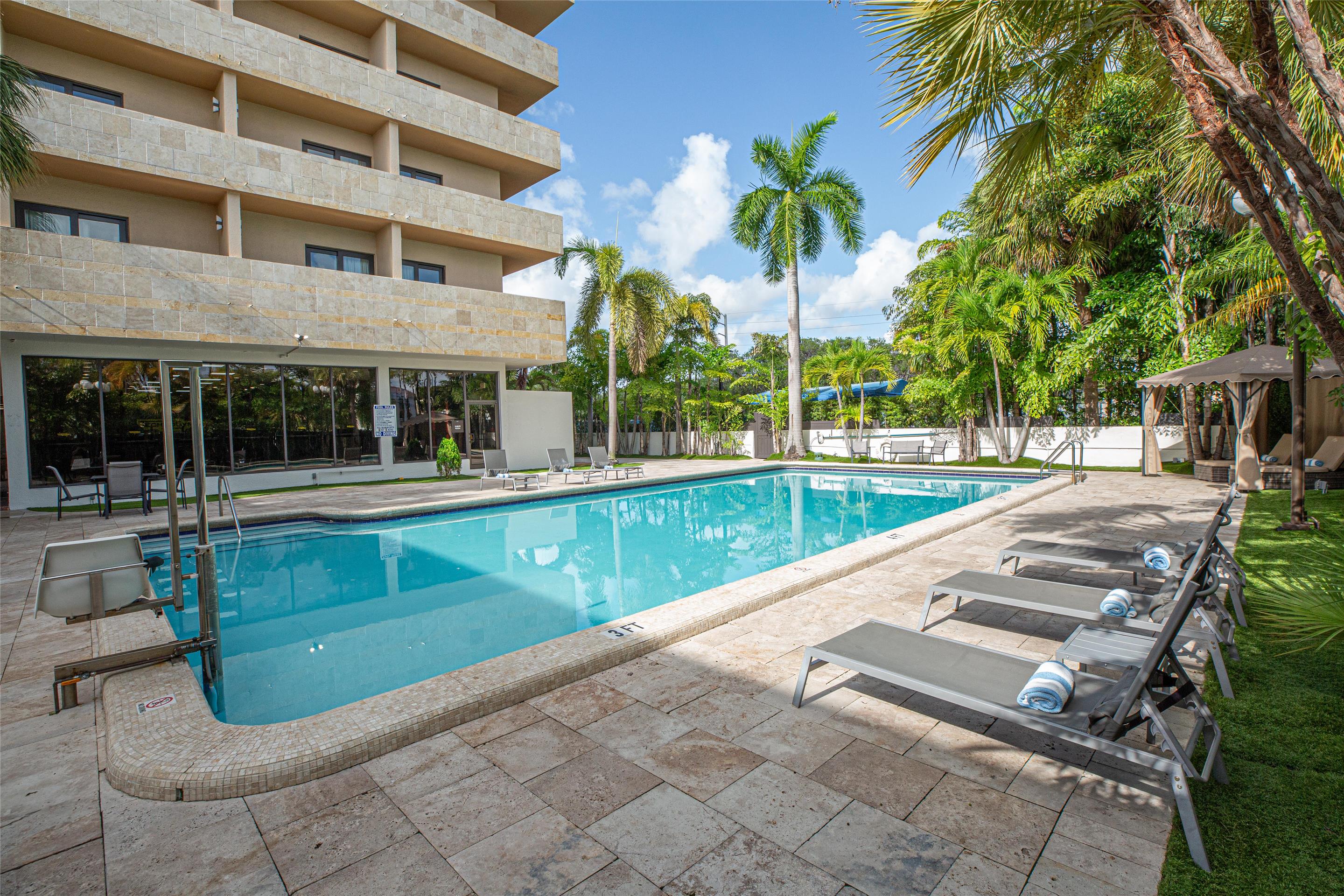 Outdoor Pool and Lounge Chairs | Regency Miami Airport by Sonesta