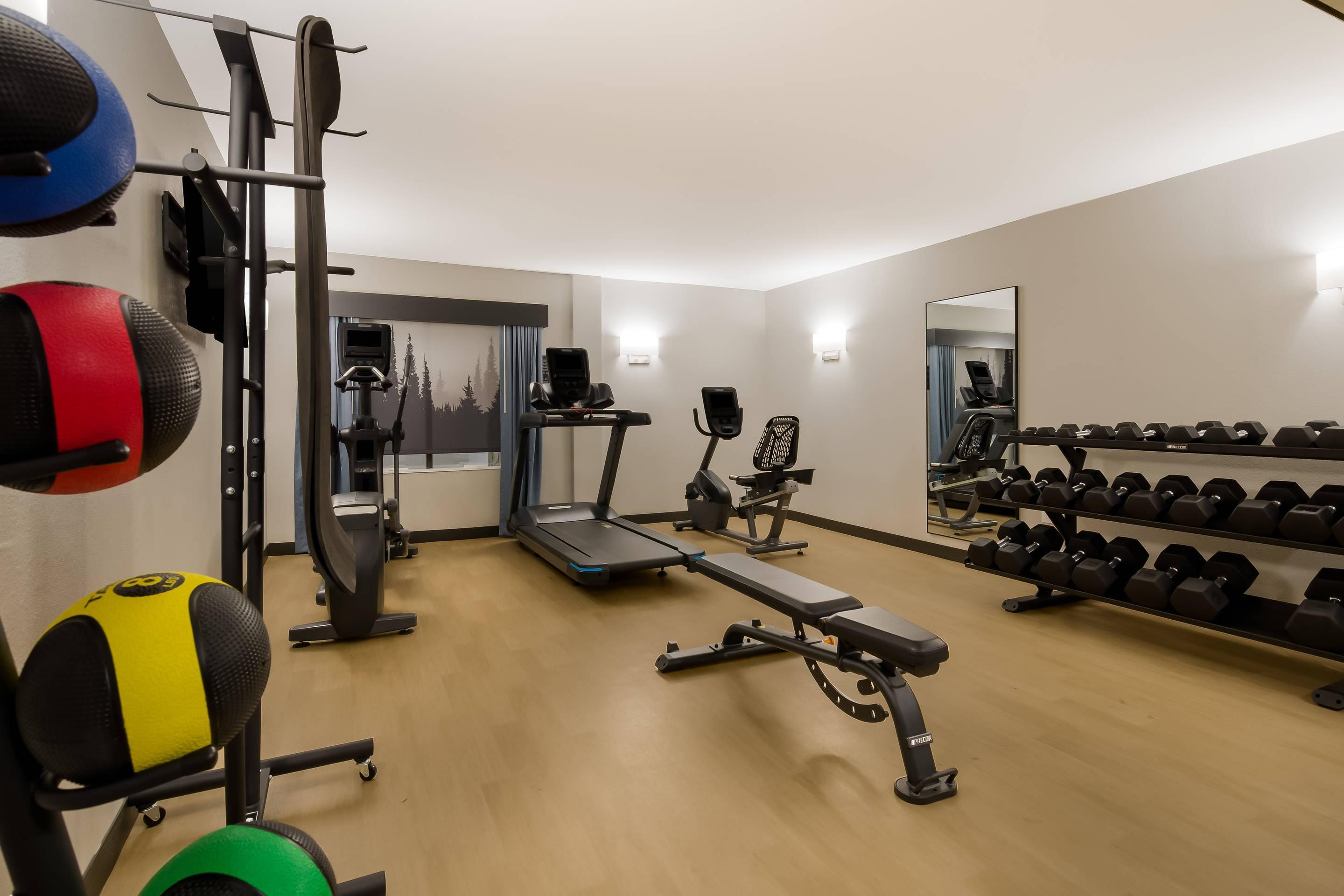 Exercise room with cardio equipment and weights | Graystone Lodge, Ascend Hotel Collection