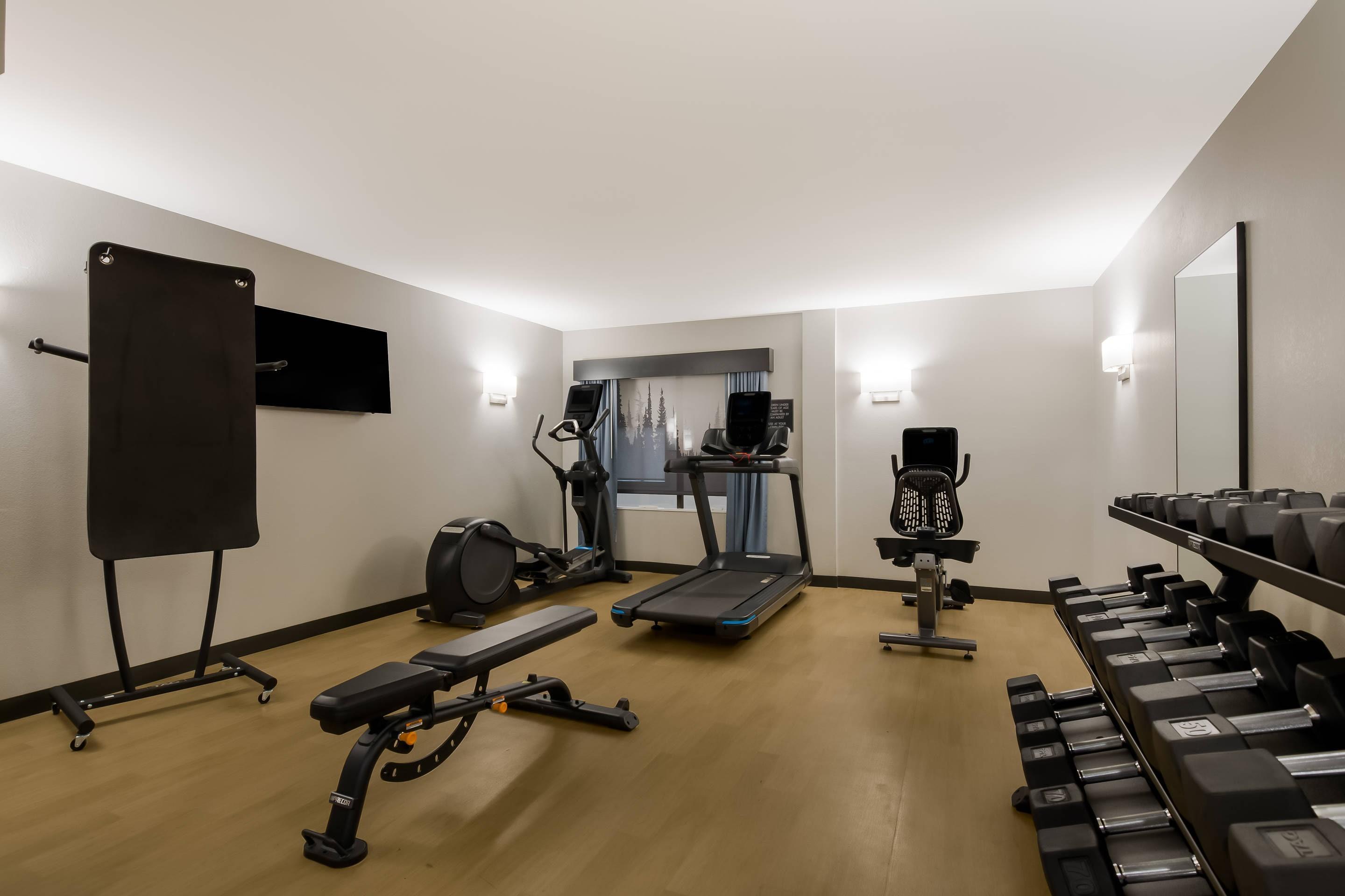 Exercise room with cardio equipment and weights | Graystone Lodge, Ascend Hotel Collection