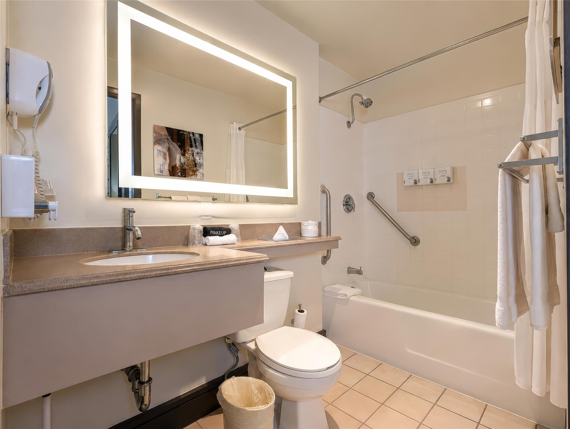 A clean bathroom with a sink, toilet, and bathtub.