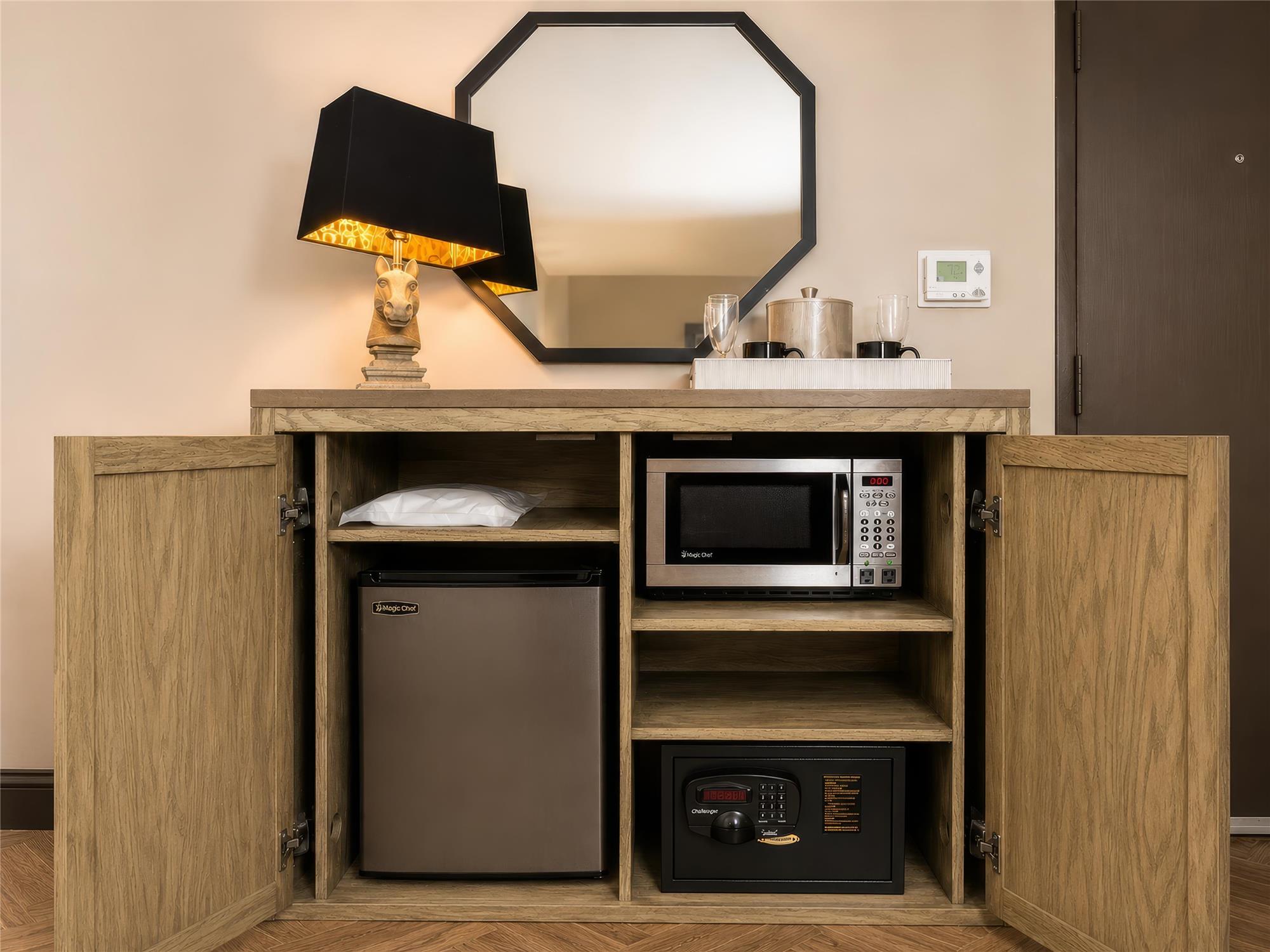 A cabinet with a microwave, mini fridge, and safe inside.
